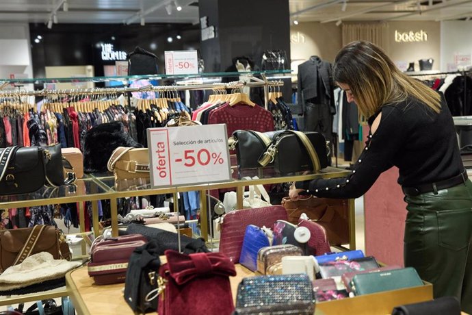 Archivo - Una mujer observa un bolso, 