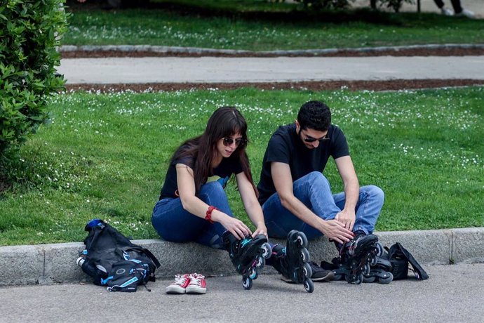 Archivo - Dos personas se ponen unos patines.