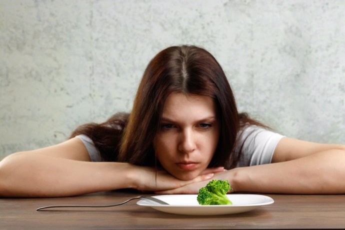 Archivo - Imagen de archivo de una mujer mirando un plato con comida.