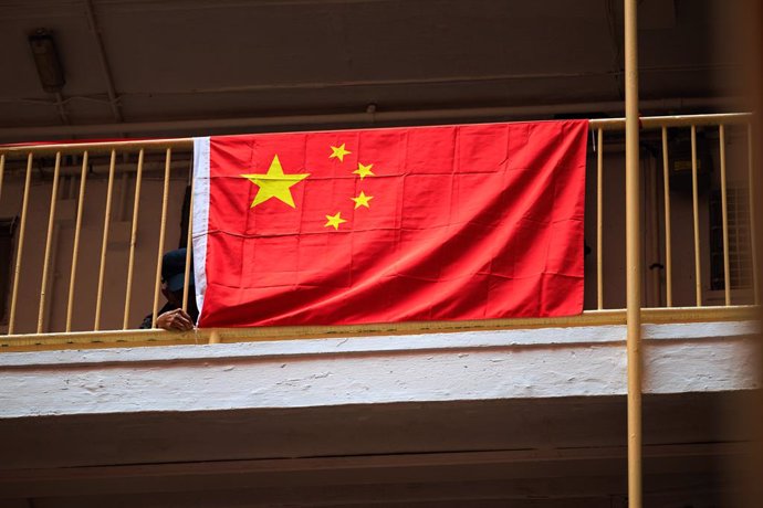 Archivo - October 3, 2024, Hong Kong, China: A man fixes a Chinese national flag at a public estate during the National Day 'Golden Week' in Hong Kong. To mark the 75th anniversary of the founding of the People's Republic of China on October 1, 2024, a va