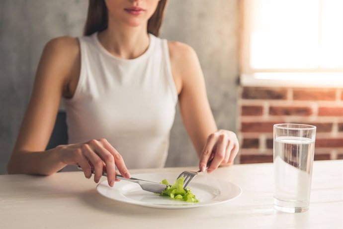 Archivo - Joven a dieta comiendo lechuga.