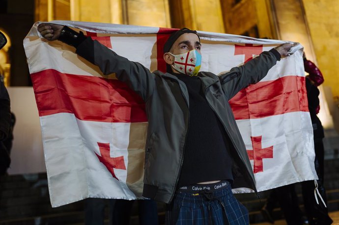 October 28, 2024, Tbilisi, Tbilisi, Georgia (Europe: A woman with a Georgian flag stands outside parliament. Thousands of demonstrators gathered in the Georgian capital Tbilisi on Monday 28 October in response to a call from the pro-Western opposition, wh