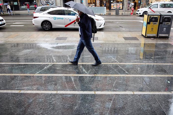 Archivo - Un hombre con paraguas camina bajo la lluvia por el centro de Madrid, a 7 de junio de 2023, en Madrid (España). 