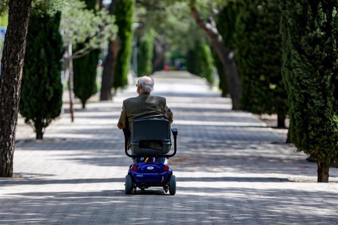 Archivo - Un anciano en silla de ruedas eléctrica en un parque, en Madrid (España), a 2 de mayo de 2020. .