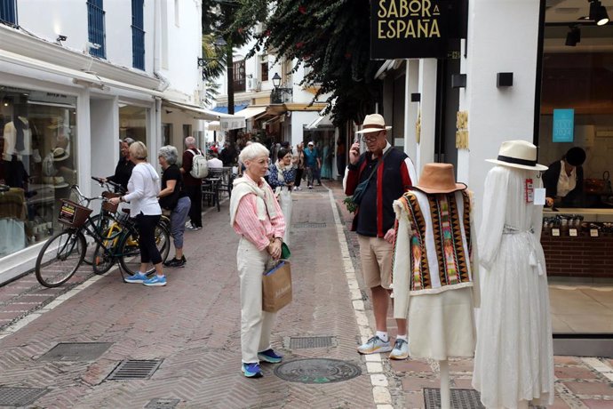 Dos turistas realizan compras en el centro de Marbella.