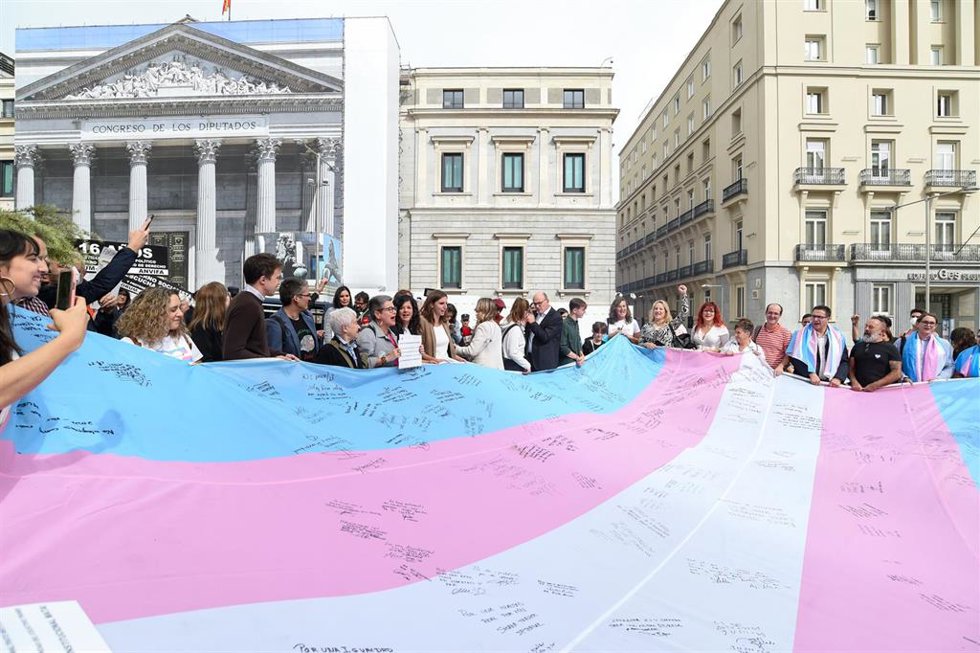 Archivo - Varias personas sostienen la bandera trans que la Federación Estatal de Lesbianas, Gais, Trans, Bisexuales, Intersexuales y más (Flegtbi+), Chrysallis y Fundación Triángulo han llevado al Congreso de los Diputados, a 27 de octubre de 2022, en