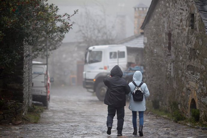 Archivo - Dos personas abrigadas en una calle del municipio de Pedrafita do Cebreiro, 13 de diciembre de 2023, en Pedrafita do Cebreiro, Lugo, Galicia (España). Un nuevo frente de frío ha entrado hoy por las montañas del este gallego, que dejará temperatu