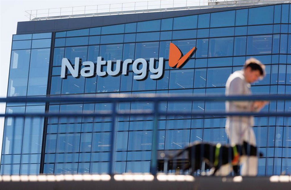 Archivo - Una persona camina frente a la sede de Naturgy, en Madrid (España)