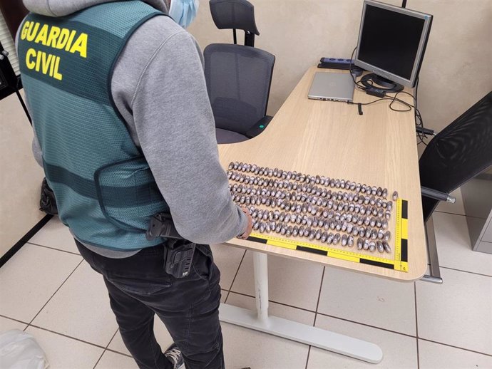 Un agente de la Guardia Civil custodia las 200 bellotas de hachís intervenidas en el aeropuerto de Palma