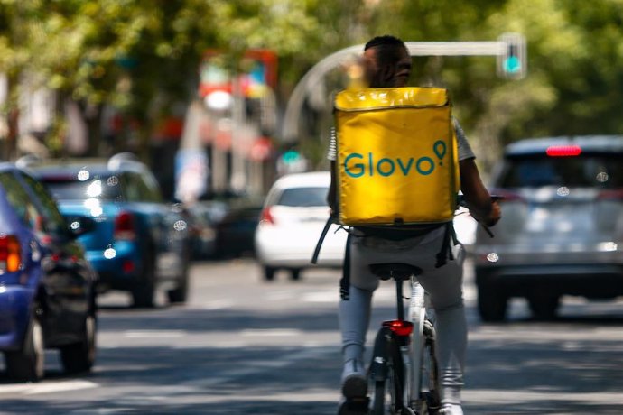 Archivo - Un 'rider' de la compañía de comida a domicilio, Glovo, circula con su bicicleta por una calle de Madrid.