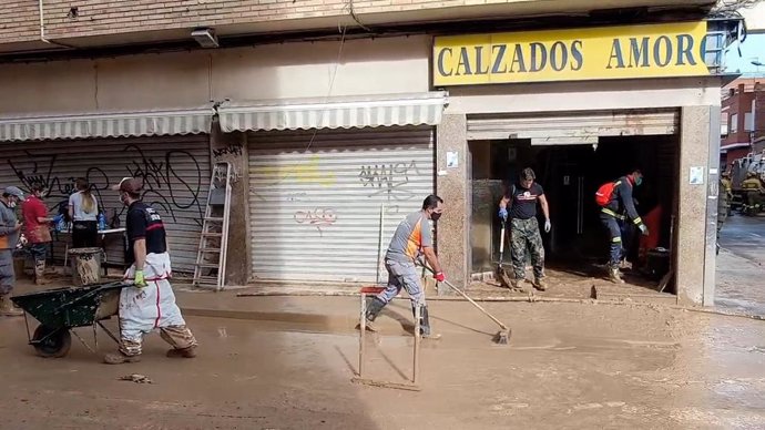 Persones netejant un sabateria a Benetússer