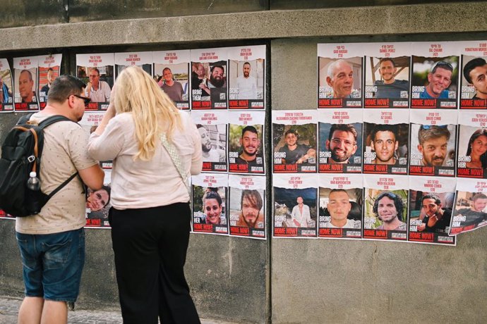 Archivo - September 7, 2024, Prague, Auvergne Rhone Alpes, Czech Republic: Israel-Hamas War 2024: Two persons stand beside pictures of Israeli hostages held by the Hamas on a well in Prague's Josefov Jewish quarter, on September 7, 2024.