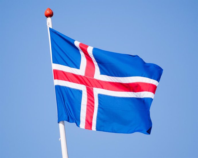 Archivo - August 2, 2015 - Vigur Island, Westfjords, Iceland - The national flag of Iceland, blue with a white cross, and a red cross inside the white cross flying on Vigur Island in Isafjordur Bay, Westfjords. Tourism has become a growing sector of the e