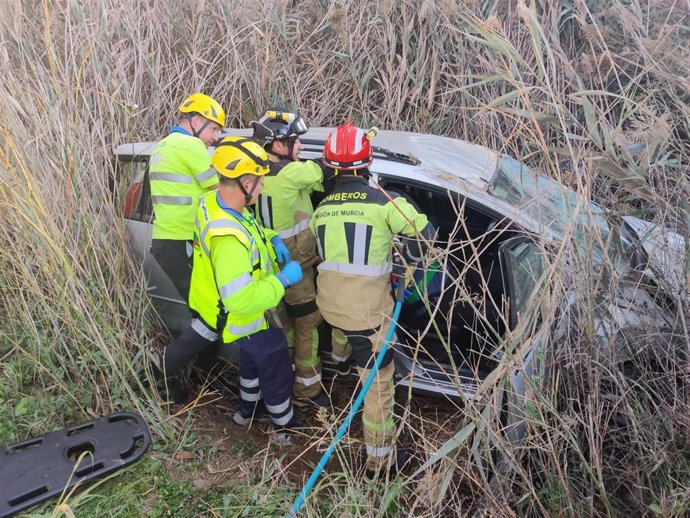 Efectivos sanitarios y del CEIS maniobran para sacar a la mujer del vehículo accidentado