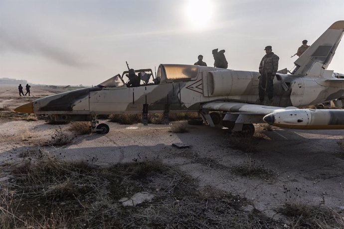 02 December 2024, Syria, Aleppo: Members of the Syrian armed opposition on top of a military aircraft after gaining control of the Nayrab military airport in the city of Aleppo. Photo: Anas Alkharboutli/dpa