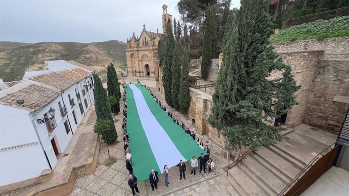 Despliegue de la bandera de Andalucía en el entorno del Arco de los Gigantes en Antequera.