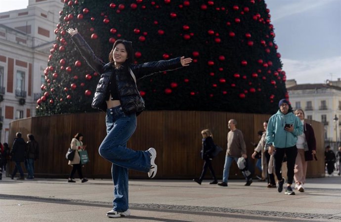 Una turista se hace una foto junto al árbol de Navidad de la Puerta del Sol, a 29 de noviembre de 2024, en Madrid (España).