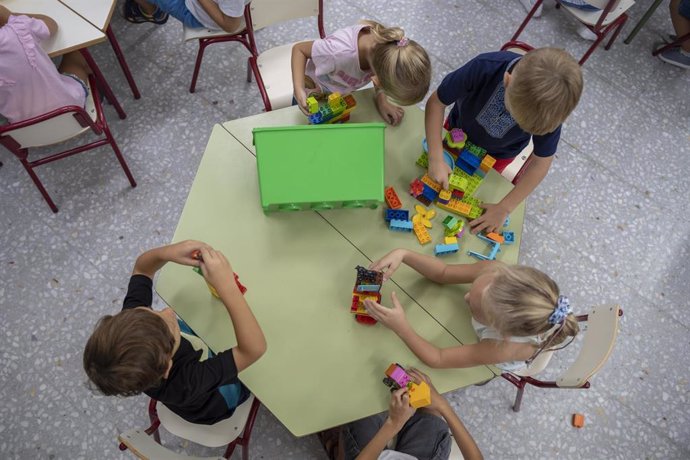 Archivo - Varios niños juegan en el colegio