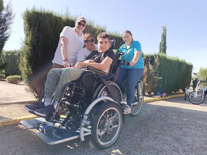 Uno de las participantes en el estudio, junto a su familia y una de sus fisioterapeutas