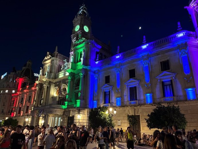 Imagen de la fachada del Ayuntamiento de València iluminada con la bandera LGTBI.