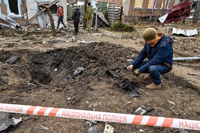 Un hombre recoge restos de un dron tras un ataque en Zaporiyia, Ucrania