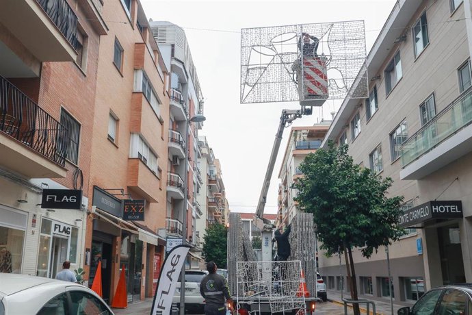 Archivo - Operarios del Ayuntamiento de Sevilla instalan las luces navideñas en el barrio de Los Remedios, en foto de archivo.