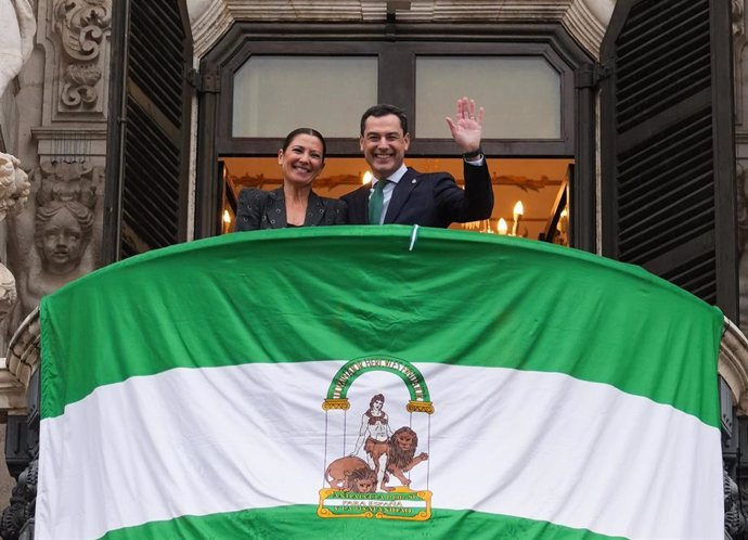 Archivo - El presidente de la Junta de Andalucía, Juanma Moreno (d), y la bailaora Sara Baras (i) despliegan la bandera de Andalucía en el balcón principal de San Telmo.  A 04 de diciembre de 2023, en Sevilla (Andalucía, España). 