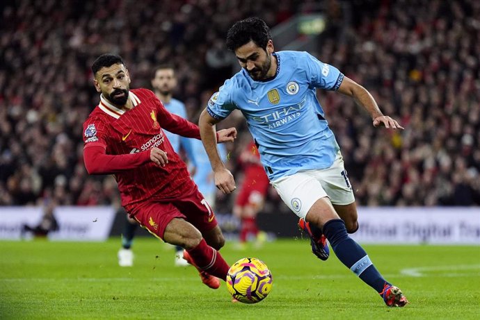 El delantero egipcio del Liverpool, Mohamed Salah, and el mediocentro alemán del Manchester City, Ilkay Gundogan, luchan por el balón.