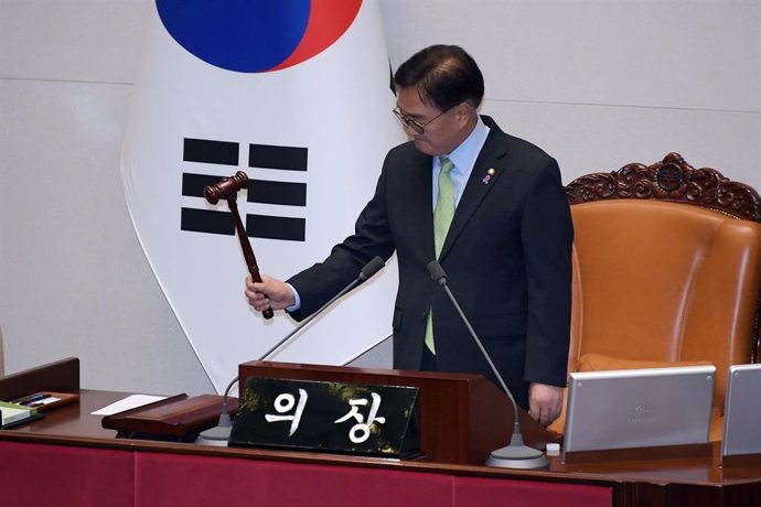 04 December 2024, South Korea, Seoul: South Korea's National Assembly Speaker Woo Won-shik bangs the gavel to announce the passage of a resolution urging the president to withdraw martial law following a vote during an emergency plenary session. South Kor