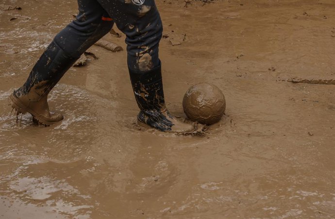 Dos chicos juegan al fútbol en Alfafar, a 8 de noviembre de 2024, en Valencia, Comunidad Valenciana (España). Diez días después de la tragedia, los servicios de emergencia apuran hasta el límite la búsqueda de desaparecidos por la DANA en Valencia. El núm