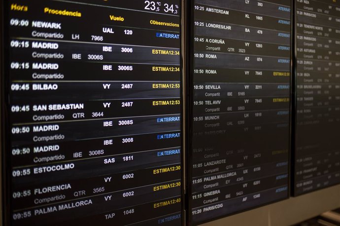 Archivo - Un panel de idas y llegadas en el aeropuerto de Barcelona.