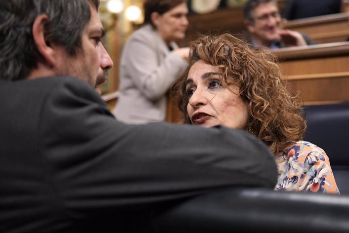 El ministro de Cultura, Ernest Urtasun (i), conversa con la vicepresidenta primera y ministra de Hacienda, María Jesús Montero (d), durante un pleno en el Congreso de los Diputados, a 13 de noviembre de 2024, en Madrid (España). 