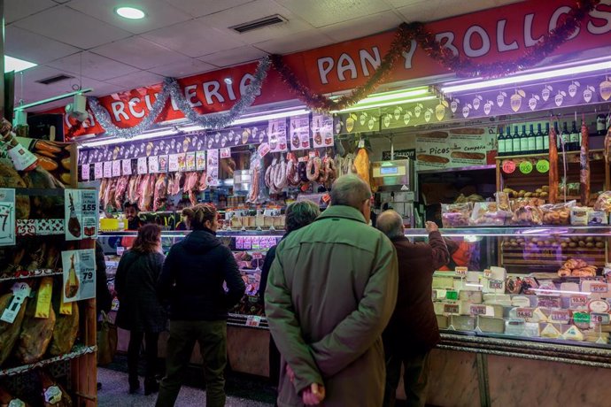 Archivo - Varias personas esperan su turno en una charcutería.