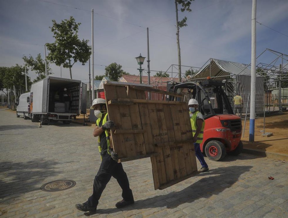 Archivo - Operarios trabajan en el desmontaje de las instalaciones de la Feria de Abril de 2020, suspendida por el Covid