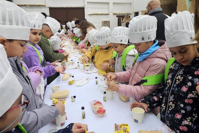 Escolares preparándose su desayuno con AOVE y cacao