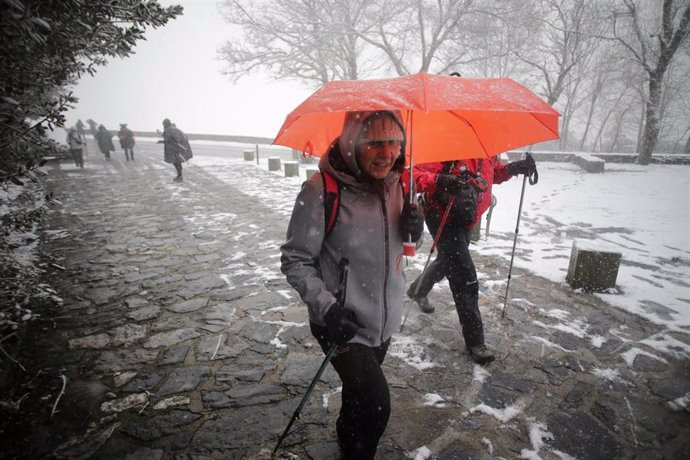 Archivo - Una persona camina con bastones y ropa de abrigo mientras nieva en la parroquia de O Cebreiro, en Pedrafita do Cebreiro, Lugo, Galicia, (España). 