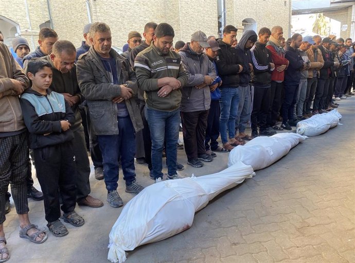 Palestinos rezan frente a los cuerpos de varios muertos a causa de la ofensiva militar lanzada por Israel contra la Franja de Gaza (archivo)