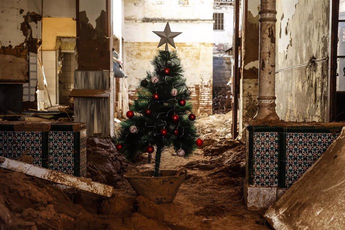 Un árbol de Navidad en una zona cubierta de barro por la Dana en Valencia