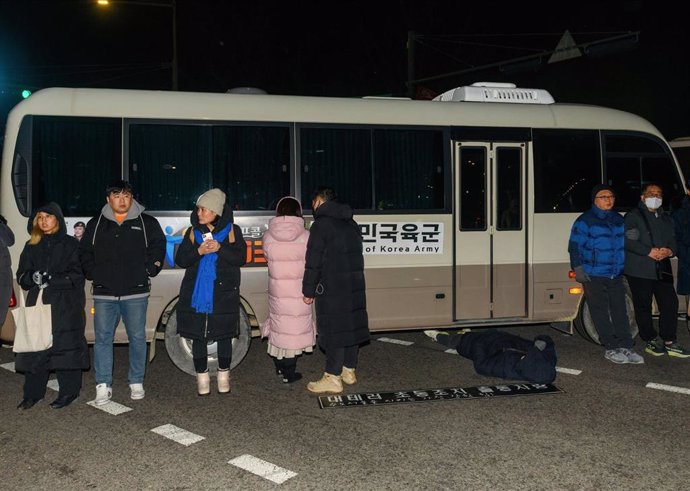 Un grupo de personas bloquea vehículos militares tras el decreto de ley marcial en Corea del Sur