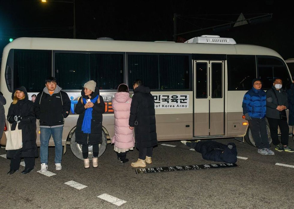 Un grupo de personas bloquea vehículos militares tras el decreto de ley marcial en Corea del Sur