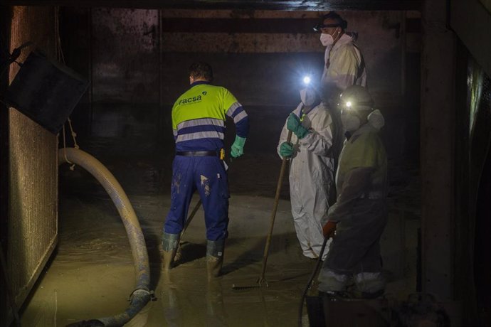 Varios trabajadores con los nuevos dispositivos para la extracción de lodo en garajes y plantas bajas en Massanassa (Valencia).