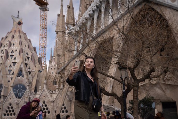 Archivo - Arxivo - Una turista treu una foto junt amb la Sagrada Família.