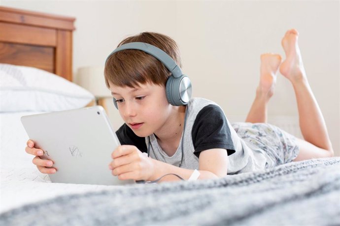 Recurso de niño con una tableta y auriculares