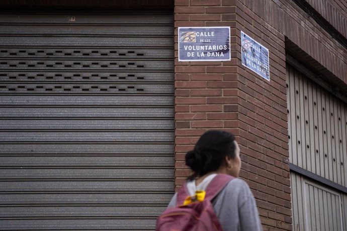 Una mujer pase por la recientemente renombrada Calle de los Voluntarios de la DANA, a 18 de noviembre de 2024, en Paiporta, Valencia