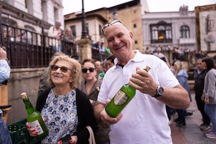 Archivo - Dos personas con dos botellas de sidra durante el acto de conmemoración del Día Mundial de la Sidra, en la plaza de la Catedral de Oviedo, a 3 de junio de 2024, en Oviedo, Asturias (España). 