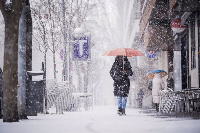 Archivo - Una persona sujeta un paraguas al caminar por una de las calles de Vitoria-Gasteiz tras la intensa nevada caída sobre la ciudad, a 27 de febrero de 2023, en Vitoria-Gasteiz, Álava, Euskadi (España). 