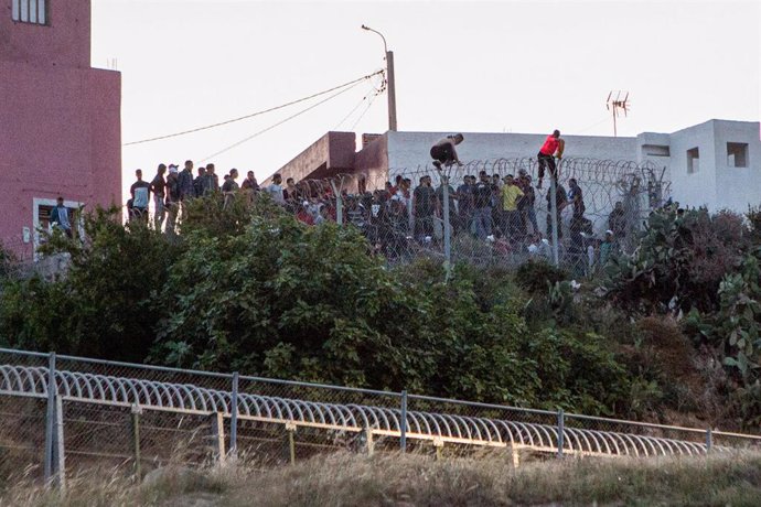 Archivo - Varios marroquíes intentan llegar a suelo español desde la frontera que separa Melilla y Marruecos, a 21 de mayo de 2021.