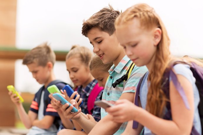 Archivo - Elementary school students with smartphones