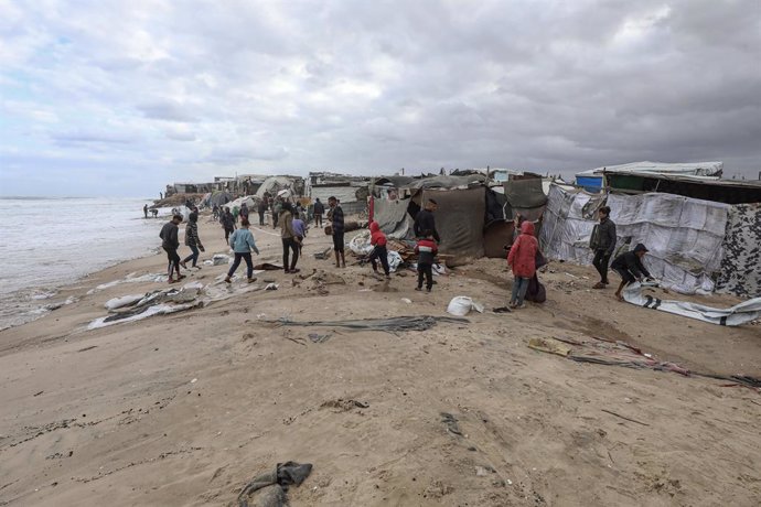 November 25, 2024, Dair El-Balah, Gaza Strip, Palestinian Territory: Displaced Palestinians gather near tents that were flooded with sea water because of the high tide combined with windy weather, along the shore of Dair El-Balah in the central of Gaza St