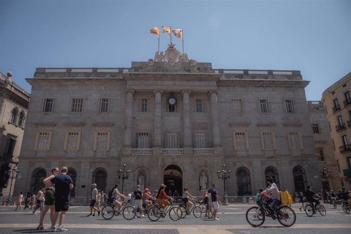 Archivo - Varias personas caminan delante del edificio del Ayuntamiento de Barcelona, a 1 de agosto de 2023